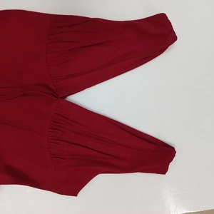 Close-up of elegant V-neckline with pleated fabric detail on burgundy strap dress