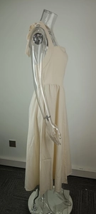 Side view of an elegant cream-colored halter neck maxi dress on a clear mannequin.