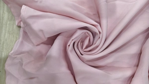 Detailed macro view showing the soft texture and neat stitching of the pink textile fabric