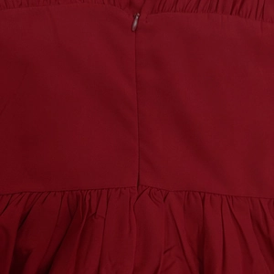 Detail shot of the back invisible zipper and waist pleating on the red floral dress