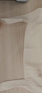 Detailed close-up shot of the smooth fabric and seam construction on a cream halter dress