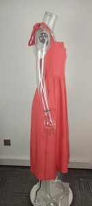 Side profile of coral pink halter neck backless midi dress on clear mannequin stand