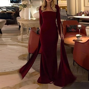 Detail of burgundy evening gown featuring dramatic cape sleeves and mermaid silhouette cut