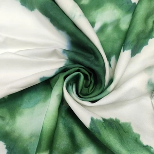 Detailed macro view of green and white tie-dye print fabric with soft swirling texture
