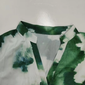 Detailed view of the V-neck and stand collar with green tie-dye print patterns