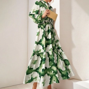 Detail of green tie-dye dress featuring a cinched waist, lantern sleeves and pleated hem