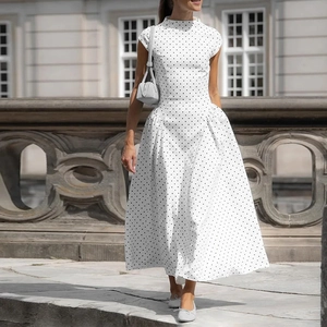 Dettaglio dell'abito bianco a pois con eleganti pieghe in vita e ampia gonna a ruota