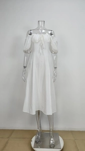 Close-up of white off-shoulder dress with puff sleeves and pleated bust detailing