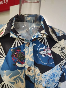 Détail du col à revers et des boutons sur une robe chemise en satin bleu imprimé