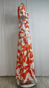 Detail of tiered skirt ruffles and orange tropical floral print on a summer maxi dress