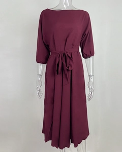 Detail van een wijnrode midi-jurk met elegante lantaarnmouwen en een ceintuur in de taille