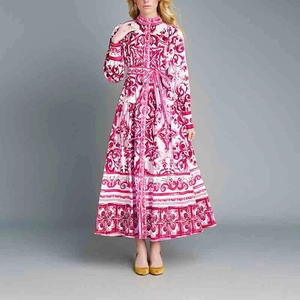 Vue de face d'une robe longue blanche à imprimé baroque rouge et manches bouffantes
