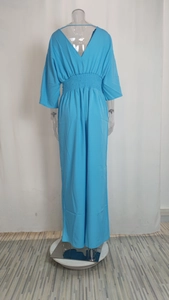 Back view of light blue v-neck jumpsuit with batwing sleeves and elastic waist details