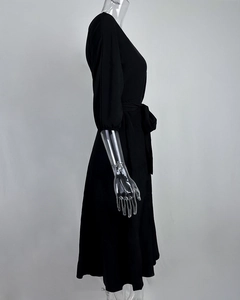 Detailweergave van de elegante zwarte midi-jurk met een stijlvol strikdetail in de taille