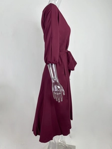 Detail van bordeauxrode one-shoulder jurk met verstelbare tailleband en elastische manchetten