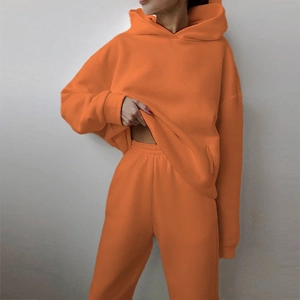 Detail of vivid orange women's tracksuit showing thick cotton fleece and kangaroo pocket