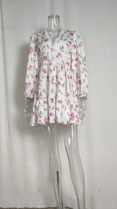 Detail of V-neck with white lace trim and floral print on long sleeve chiffon dress