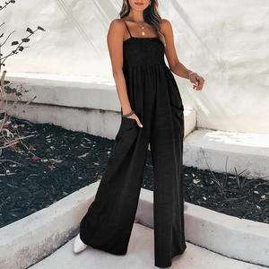 Detail of smocked chest design and side pockets on a black wide leg jumpsuit