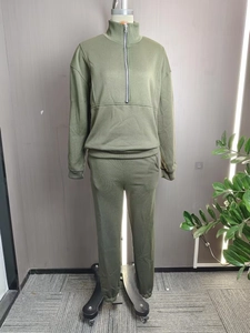 Close-up of olive green tracksuit featuring a half-zip sweatshirt and ribbed cuffs