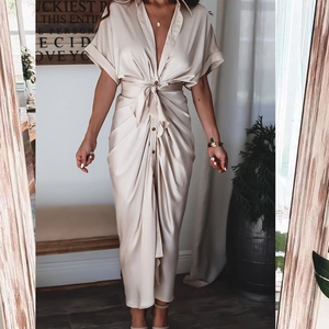 Détail d'une élégante robe en satin champagne avec décolleté en V et ceinture nouée