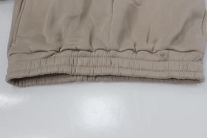 Detailed macro shot of the beige tracksuit pants elastic waistband and stitching