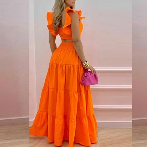 Detail of orange two-piece set with ruffled crop top and layered high-waist maxi skirt