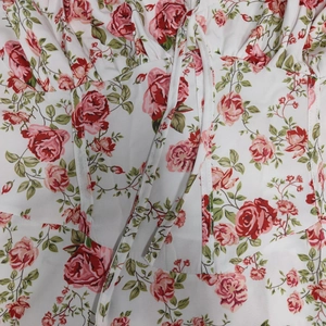 Detail of red rose floral print on white chiffon dress with lace-up corset bodice design