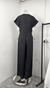Rear view detail of black short sleeve jumpsuit with hidden zipper and high waist cut