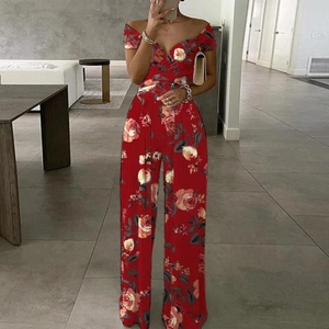 Dettaglio della stampa a rose rosse su una tuta con spalle scoperte e gamba ampia