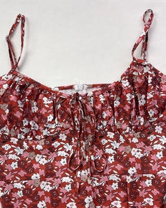 Gros plan sur robe à fleurs rouges avec bretelles, fronces et détails de nœuds