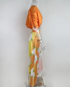 Detailed side view of orange puff sleeve top and floral maxi skirt set for summer beachwear