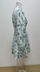 Detail of light blue floral dress with white lace V-neckline and tiered ruffle hemline