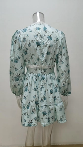 Detail view of floral long sleeve dress showing back white lace trim and tiered skirt hem