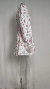 Detail view of the floral print pattern and elastic cuffs on white long sleeve mini dress