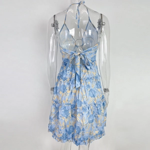 Detail of floral halter dress featuring an open back with a large decorative blue bow tie