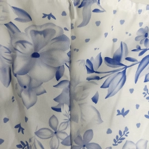 Detail of the invisible zipper and blue floral print on white cotton fabric dress
