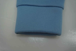 Detail shot of the tight sky blue knitted ribbed cuffs on a casual hooded tracksuit
