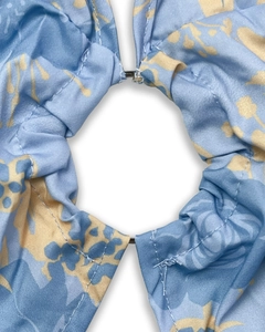Macro detail of the central metal ring connecting floral fabric cut-outs on a dress