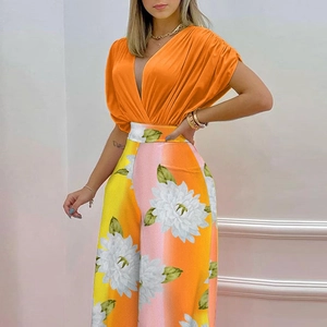 Detail of vibrant floral print on wide-leg trousers and pleated batwing short sleeves