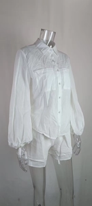 Detailed close-up of white long sleeve shirt with utility pockets and matching shorts