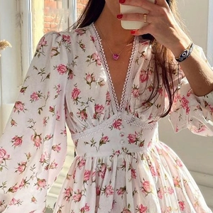 Detail of floral print V-neck dress with lace trim and elegant long puff sleeves