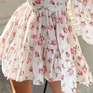 Detail of floral print mini dress showing button front and tiered ruffle hemline
