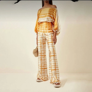 Detail view of smooth satin-finish floral print off-shoulder top and wide-leg trousers