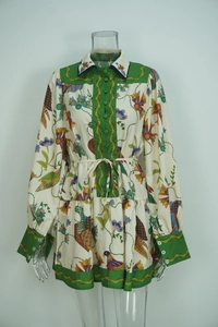 Detail of floral bird print dress with green trim and matching waist tie belt
