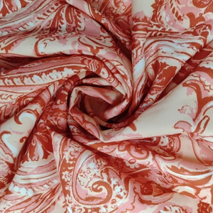 Dettaglio del tessuto in chiffon paisley rosa con morbide balze e movimento fluido