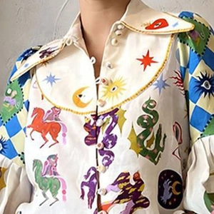 Close-up of artistic graffiti print shirt featuring fantasy horse and sun patterns