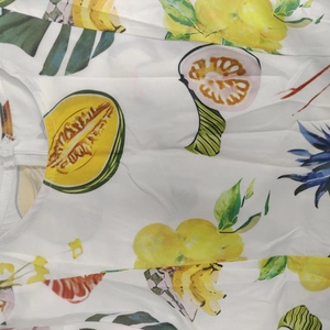 Détail du tissu à imprimé fruits tropicaux avec fermeture éclair invisible pour robe