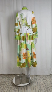 Détail d'une robe maxi imprimée colorée avec des motifs de dragon et manches lanternes