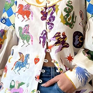 Detail of colorful illustration print and decorative buttons on white cotton shirt