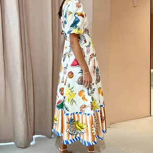 Détail de la robe blanche à imprimé tropical avec toucan, ananas et manches bouffantes